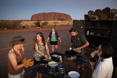 A budget backpacker tour group washes up after eating dinner in the Uluru bus sunset viewing area.   Tourists are rushing to climb world heritage-listed Monolith, Uluru in Australia's central desert...