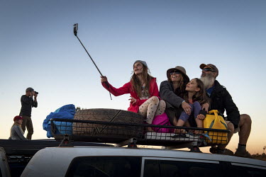 Eric Davey, Susan Daebritz with their daughters Stella and Tess take in the view of Uluru at Sunset on top of the vehicle.   Tourists are rushing to climb world heritage-listed Monolith, Uluru in Au...