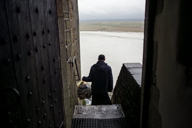 A monk carries rubbish down from their quarters in Mont Saint Michel.