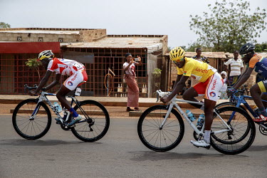 A woman on the roadside takes a picture as the riders make their way into the capital on the Yako Ziniare via Ouagadougou stage of the 'Tour du Faso'.