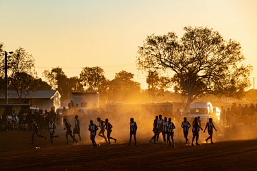 The home side, the Yuendumu Magpies, walk on to the oval for a match shortly before sunset during the Yuendumu Australian Rules Football Carnival.  Once a year Football teams from all over Central A...