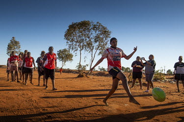 Sarah Marks from Lajamanu women's Australian Rules Football team kicks a ball to team mates during a warm up session at the Yuendumu Australian Rules Football Carnival. This year (2019) eight women's...
