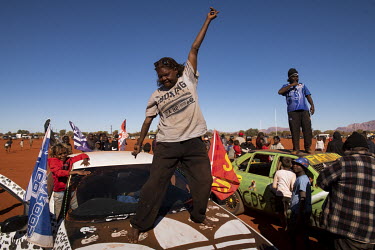Kathy from the Mutijulu community near Uluru breaks out in a spontaneous dance in front of a crowd gathered to admire a car show taking place shortly before the finals of the Yuendumu Australian Rules...