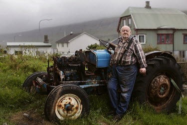 Tor Egil Oervat Odd (65) beside an old tractor outside his home, in the village Sand on Sandoy. He has never been married. He likes to repair old tractors and cars.