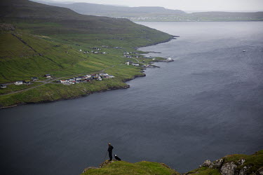 A man and his dog look for sheep in the hills above Sund outside Torshavn, the capital.