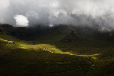 A road through the landscape, surrounded by green hills and steep mountains. The weather on the Faroes is characterised by rapid changes, with mild winters and cool summers, marked by lots of rain and...