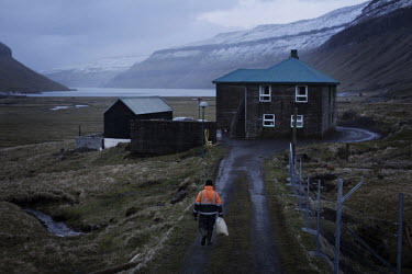 Paetur walking towards his home in Kaldbaksbotnur after feeding sheep. He says that the close relationship between family members in the Faroese culture becomes a substitute and a security for unmarri...