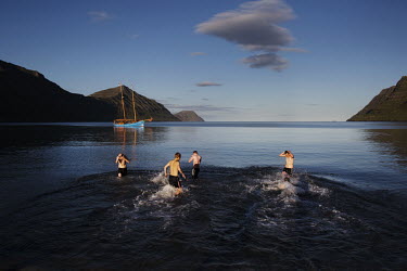 Young men take an evening swim in the cold waters during the G! music festival in Sydrugota. The G! Festival is an outdoor music festival which takes place on the beach of the village which is also ho...