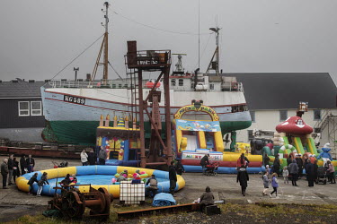 People gather at a temporary amusement park on the harbour in Vagur in the south of the Faroe Islands, during the Joansoeka midsummer festival.