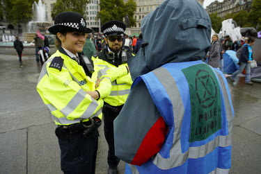 An Extinction Rebellion 'Police Liaison Officer', speaks to police among campaigners protesting for more action on climate change in Trafalgar Square.
