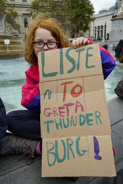 A young family from Bristol with homemade signs in support of climate activist Greta Thunberg join Extinction Rebellion campaigners protesting for more action on climate change in Trafalgar Square.
