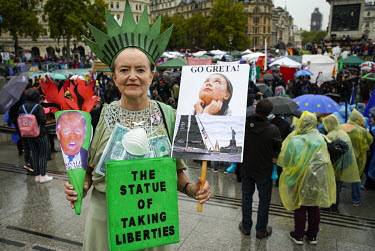 A woman dressed as the Statue of Liberty protesting against President Donald Trump and in support of Greta Thunburg during Extinction Rebellion protests in Trafalgar Square.