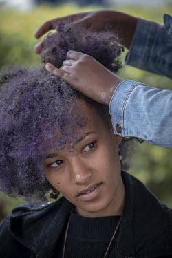 A woman has her hair styled for 'Hairitage Chronicles. A festival for the Natural Hair Community'.