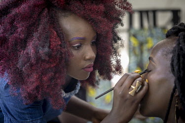 A woman applies make-up during 'Hairitage Chronicles. A festival for the Natural Hair Community'.