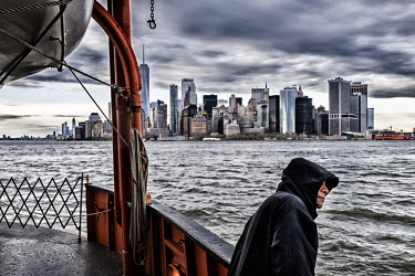 A man looks at the view of New York from the Staten Island Ferry.