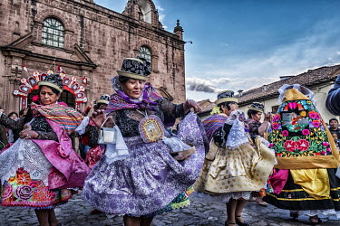 In front of the cathedral, women dance the Kapac Chunchu, a dance of native warriors from the jungle who have sworn to protect the Virgin as she is carried around the town during the fiesta. Masks and...