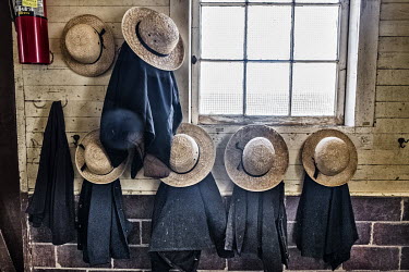 Hat and Jackets of Amish school children hanging outside the classroom.