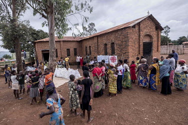 People wait as a team from the Catholic charity Caritas distributes food supplies to those affected by Ebola outside a church in the town of Marabo.