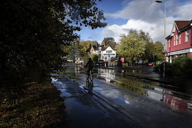 A man cycles through the rain in the village of Chandler's Ford, in the borough of Eastleigh.