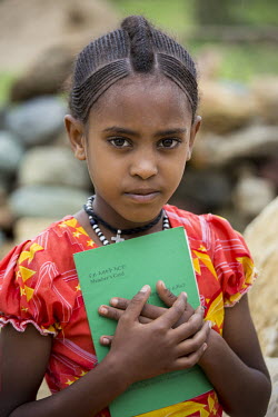 Elianne, holds her mother's Village Economic and Social Association (VESA) savings book in Mahbere Himet village.