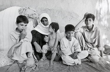 Roshanogol, a widow, sits in her home with her children in the village of Qarabagh. During the Taliban's control over the Shamali Plain region she escaped with her children to Kabul and found a shelte...