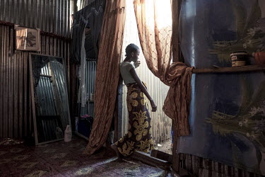 An undocumented migrant stands in the doorway of her new home (a shack made with corrugated zinc sheets) in a slum near Majicavo Koropa.