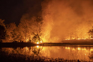 An out of control fire rages around a lake as weather conditions in New South Wales (NSW) have made circumstances ideal to spread catastrophic fires.