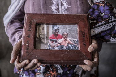 Sahirat Saidina (49) displays a photograph of her son Abdul Razak Touarhidin, who died on the crossing to Mayotte in 2013 at the age of 16.