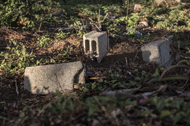 Graves of migrants drowned at sea are marked by old concrete blocks in the town cemetery.