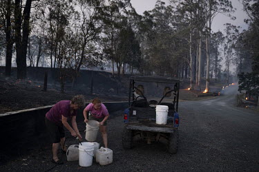 Silvia Rowort and granddaughter Estelle Mcleod fill buckets with water to help put out spot fires on their property. Weather conditions in New South Wales (NSW) have made circumstances ideal to spread...