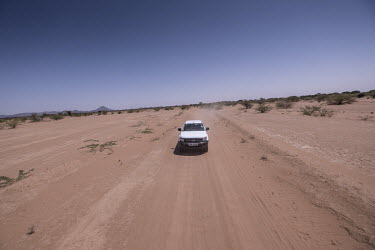 A Sightsavers' vehicle drives along a dirt road transporting medical staff to a rural clinic where they will perform a series of Trachoma surgeries.