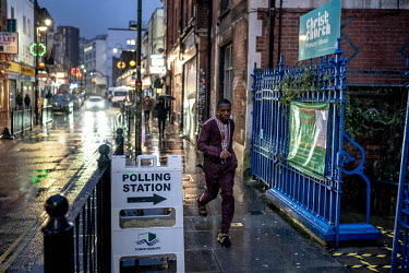 A man runs through the rain to a polling station in east London about five hours before voting ended in the 2019 General Election.