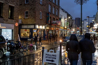 People walk through the rain past a polling station in east London on the evening of the 2019 General Election.