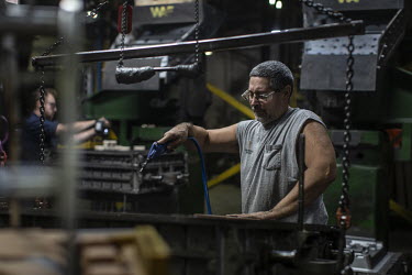 Employee Scott Hershfield moulds engine housing components at the Wisconsin Aluminum Foundry. The company has seen orders collapse during an emerging recession in the manufacturing sector.