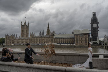 A couple from Hong Kong (U Kei Leong and Sally Chen) have their wedding photos taken with the Houses of Parliament in the background.