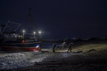 Fishermen prepare to pull their boat ashore on Hastings beach. Hastings has the largest beach launched fishing fleet in the world, but fishermen say that new UK regulations banning fishing within a m...