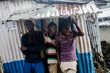 Teenagers shelter from a rainstorm at the height of the 2014-2015 Ebola outbreak.