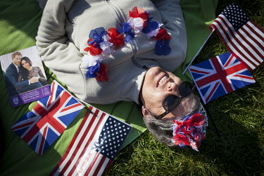 Crowds gather in Windsor to see the Royal Wedding Clare Moore (53) originally from Scotland, who has been living in New Jersey for 30 years and recently moved back to the UK, lies on the ground among...