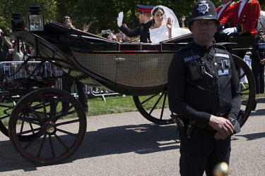 A policeman keeps watch as the Royal Couple ride through WIndsor in a horse drawn carriage on the morning of the 19 May 2018 Royal Wedding between Prince Harry and Megan Markle.