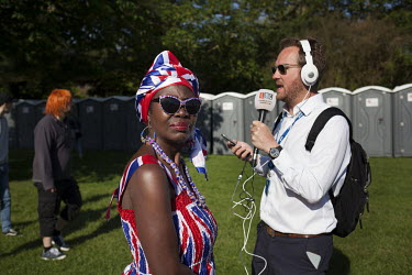 A radio reporter and Grace Gothard from Surrey in Windsor on the morning of the 19 May 2018 for the Royal Wedding between Prince Harry and Megan Markle. Grace says, ''I'm not giving my age, Africans d...