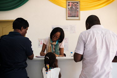 Grace Kudzu, 35, with a young patient and her parents at the National Sickle Cell Research and Care Centre where she volunteers. Grace suffers from sickle cell disease herself, and volunteers full-tim...