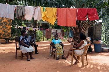 Grace Kudzu (right) and her friend Ismael M-Tanko (second from left) visiting Selasse de Souza and her mother Grace Domety at their home. Selasse suffers from sickle cell disease and has difficulty sp...