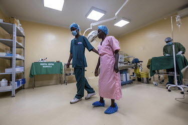 Members of the surgical team help Sahura Mussa out of the operating theatre after a successful cataract operation at the Nampula hospital.