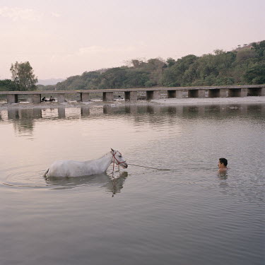 A man washing his horse in the Rio Grande O Nacaome.