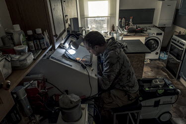 Fossil collector and preparer James Carroll works on a rock containing many ammonites in his studio-kitchen in Axminster. The work requires extreme care and precision, a challenge for Carroll who has...