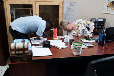 Bongani Bheki Myeni and Thea Litschka-Koen calmly looking under her desk as a highly venomous twig snake briefly escaped Myeni while its enclosure was being cleaned in Litschka-Koen's office at the Si...