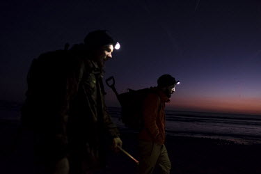 Fossil collector and preparer James Carroll, and fellow collector Dan Brownley, from the Charmouth Heritage centre, walk along Charmouth Beach after dark in search of fossils. Some collectors routinel...