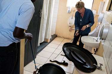 Thea Litschka-Koen catching a puff adder that had entered a mens toilet at a fertiliser production factory in Simunye.  Thea Litschka-Koen's involvement with snakes began after one of her sons had to...