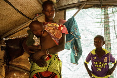 A Fulani woman breast feeding her baby. The Yattara family have been living in a shelter in Gibo for six months after they fled their village of Guika. Jihadists came to their village and told the res...