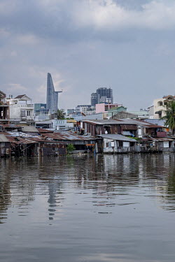 A view of the Bitexco tower in the city centre, seen from an area of slum housing lining a river in District Four.